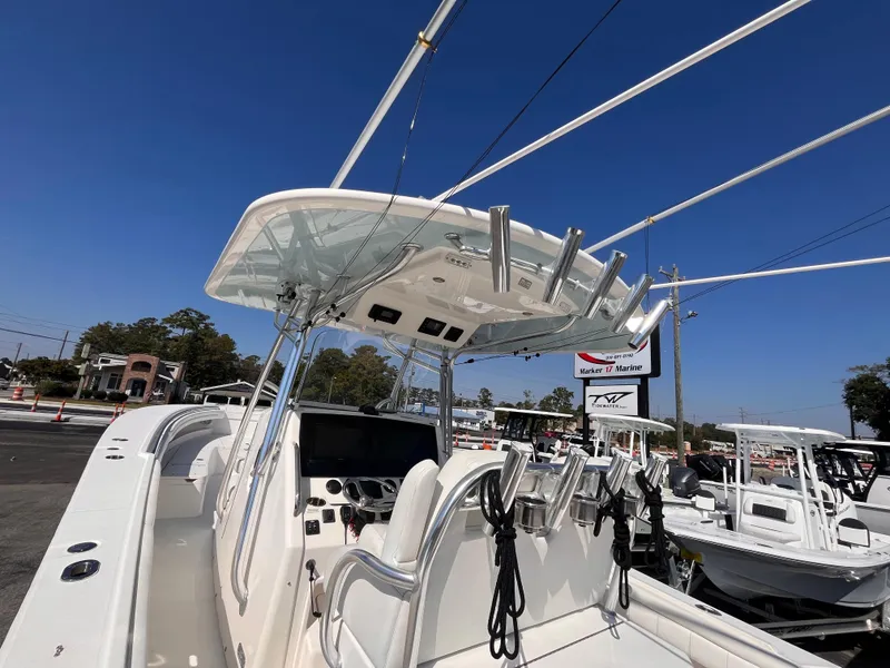 Slide: The Image of 2018 Regulator 34 boat with T-top and fishing rod holders, displayed outdoors. - 20