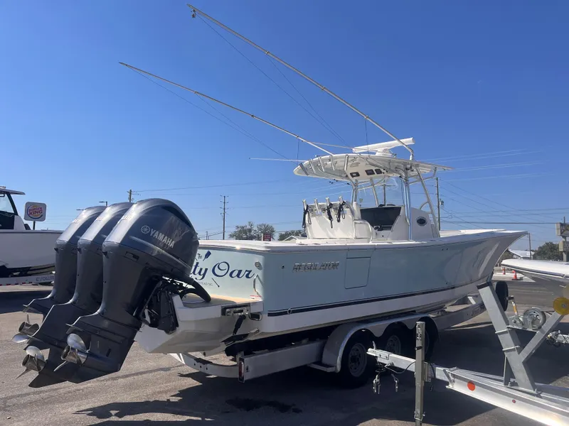 Slide: The Image of 2018 Regulator 34 boat on trailer with Yamaha engines, under clear blue sky. - 5