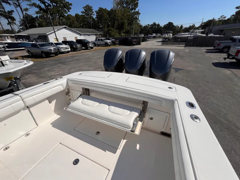 Slide: The Image of 2018 Regulator 34 boat with triple engines, white interior, and outdoor setting. - 7