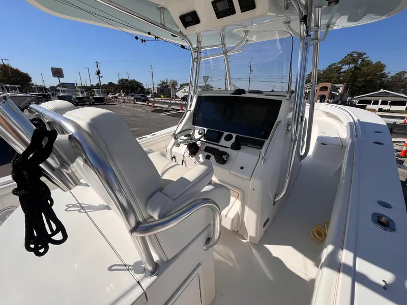 Slide: The Image of 2018 Regulator 34 boat cockpit with helm, steering wheel, and seating in marina setting. - 9