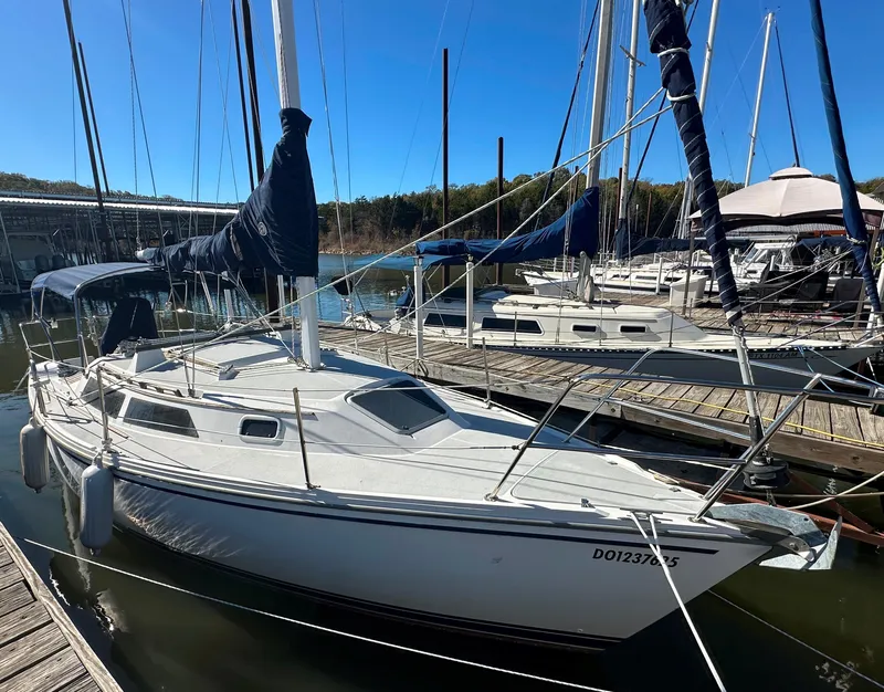 The Image of 1991 Catalina 28 sailboat docked at marina under clear blue sky. - 0