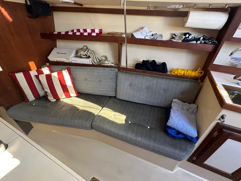 Slide: The Image of Interior of 1991 Catalina 28 sailboat with striped cushions and storage shelves. - 17