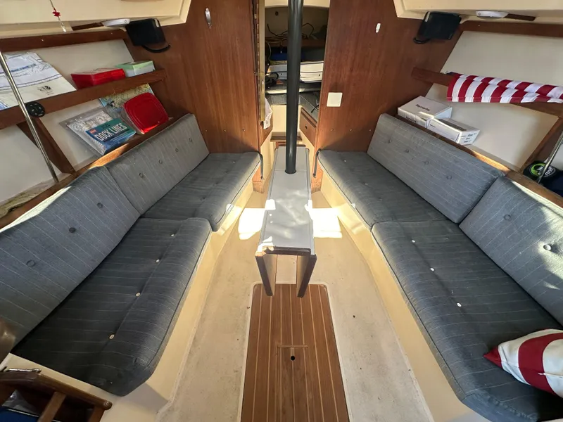 Slide: The Image of Interior of 1991 Catalina 28 sailboat with gray seating and wooden accents. - 18