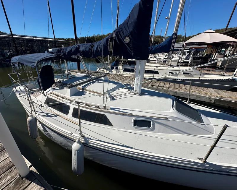 Slide: The Image of 1991 Catalina 28 sailboat docked at marina under clear blue sky. - 2