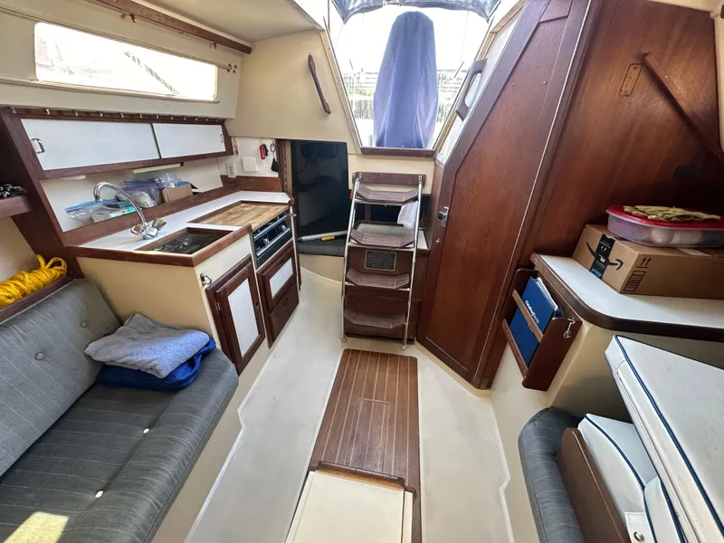 Slide: The Image of Interior of a 1991 Catalina 28 sailboat, featuring a cozy cabin with kitchen and seating area. - 21