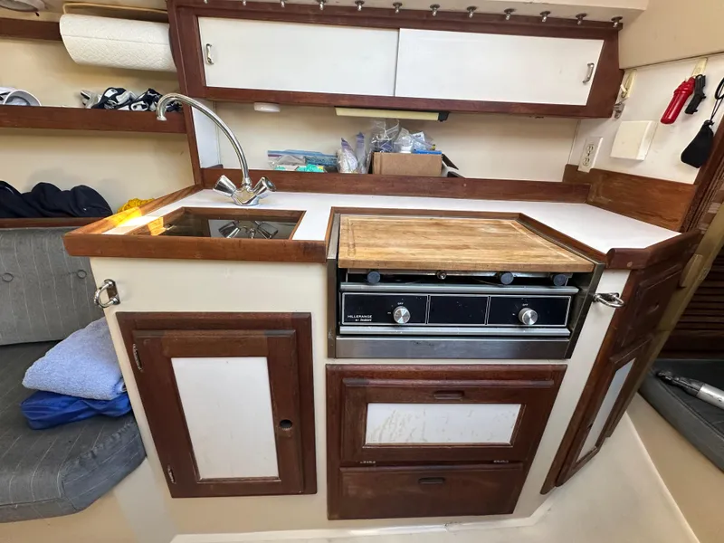 Slide: The Image of Catalina 28 sailboat kitchen interior, featuring a compact sink and stove, 1991 model. - 23
