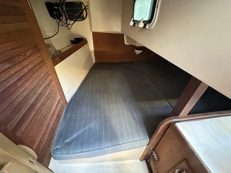 Slide: The Image of Cozy cabin interior of 1991 Catalina 28 sailboat with cushioned berth and wooden accents. - 31