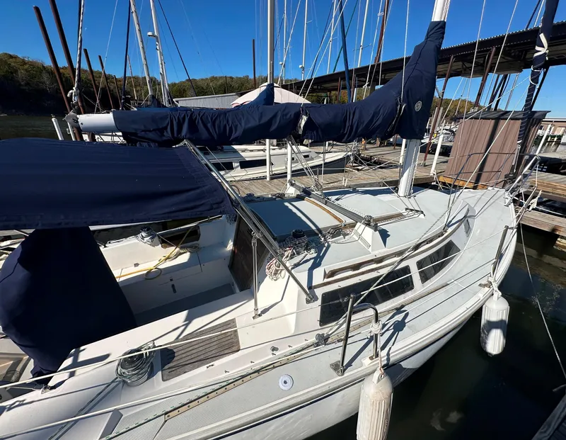 Slide: The Image of 1991 Catalina 28 sailboat docked at marina, featuring blue covers and sleek design. - 4
