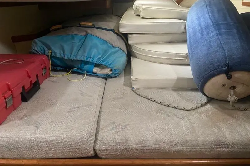 Slide: The Image of Interior storage area of 1993 Pacific Seacraft 44 Voyager with cushions and gear. - 14