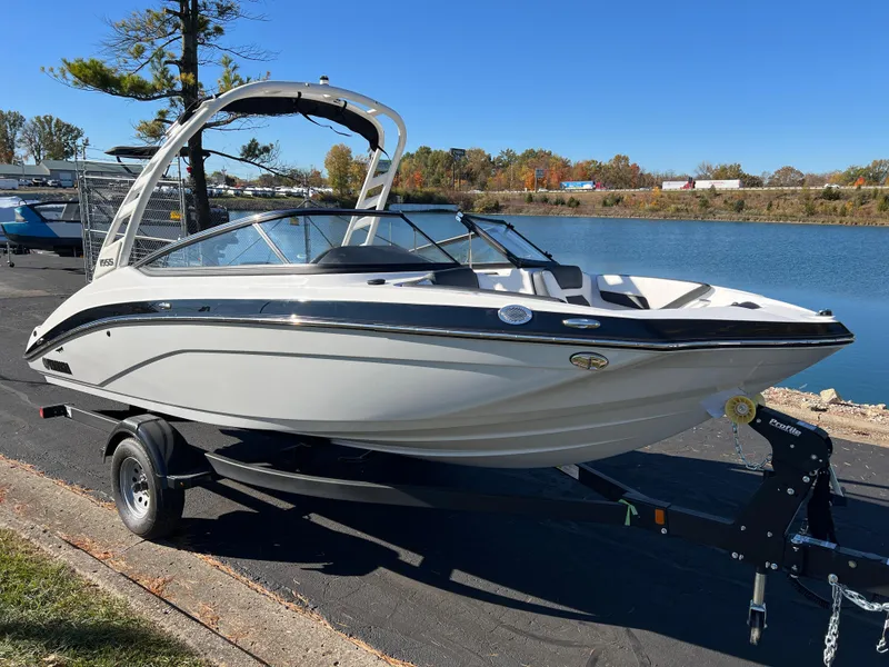 Slide: The Image of 2025 Yamaha Boats 195S on trailer by a lake, under clear blue sky. - 3