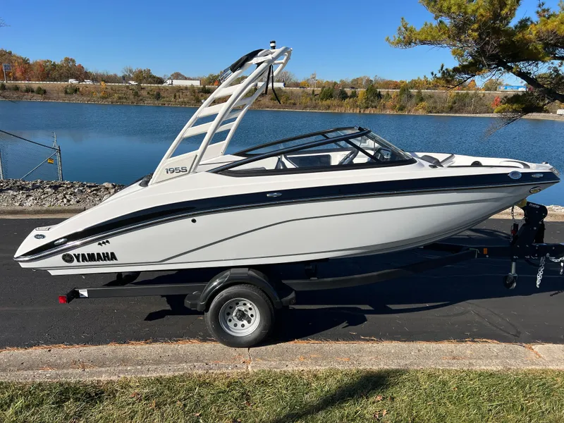 Slide: The Image of 2025 Yamaha Boats 195S on trailer by a scenic lake. - 4