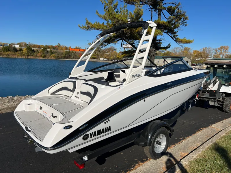 Slide: The Image of 2025 Yamaha Boats 195S on trailer by a lake, ready for launch. - 5