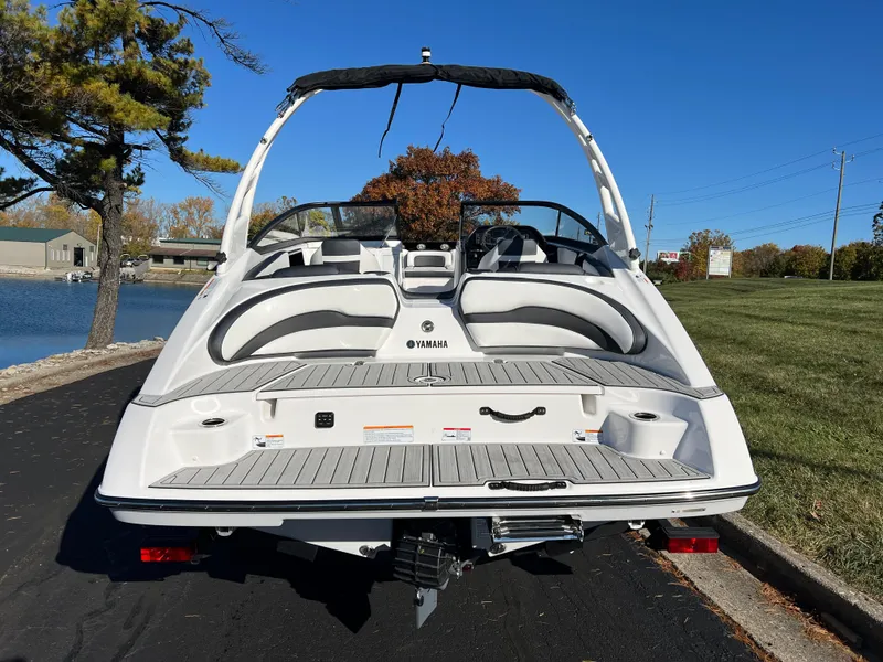 Slide: The Image of 2025 Yamaha Boats 195S, sleek design, rear view, parked near a lake. - 6