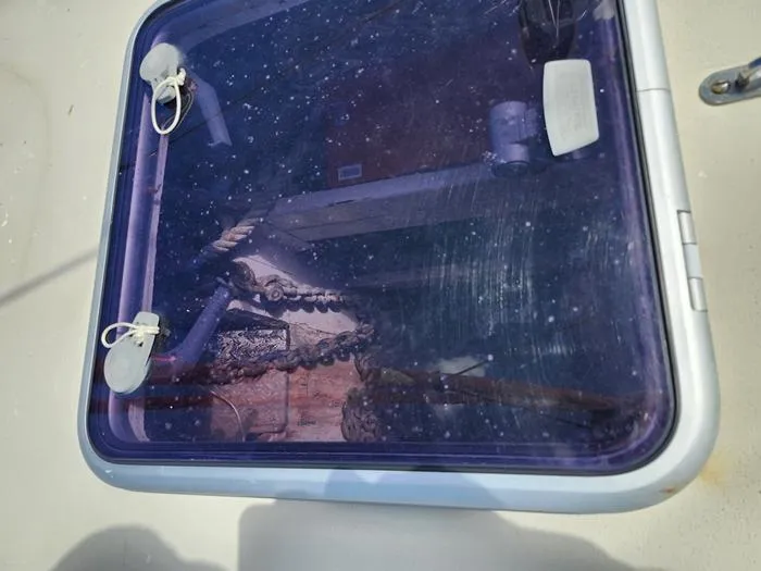Slide: The Image of 1983 Morgan Schooner hatch with visible chains and equipment inside. - 13