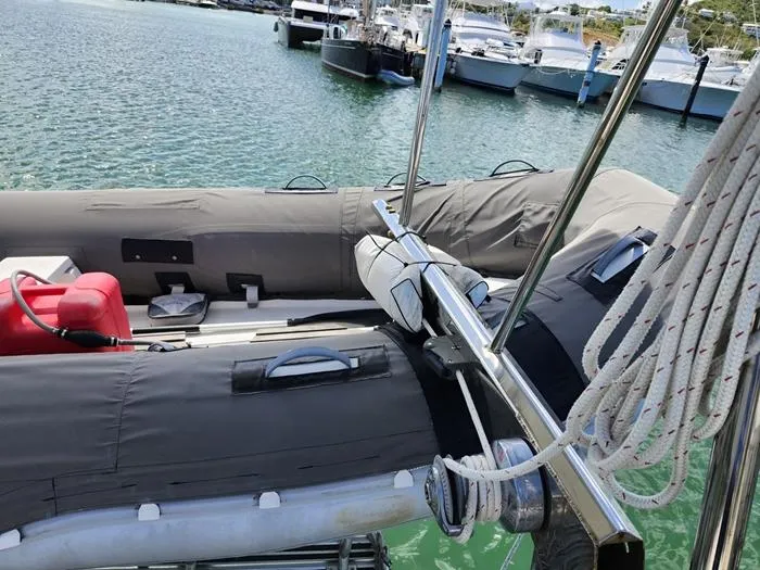 Slide: The Image of 1983 Morgan Schooner with inflatable dinghy docked in a marina, featuring ropes and water view. - 2