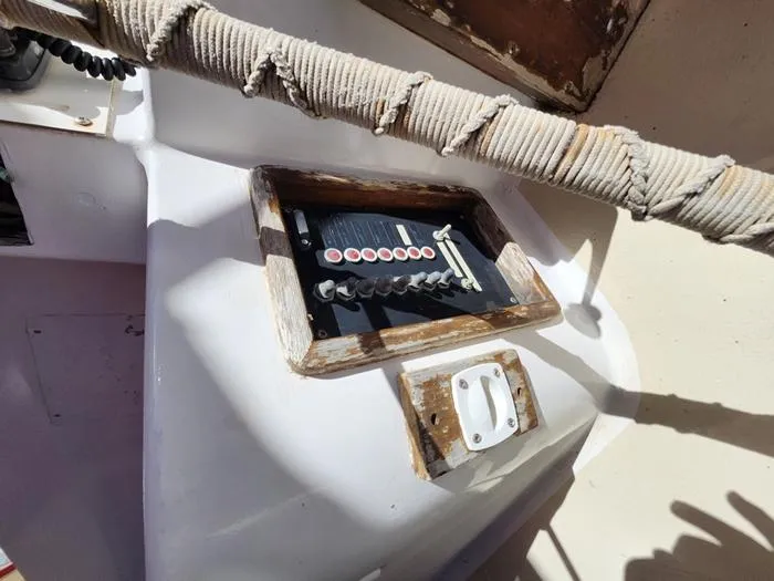 Slide: The Image of Control panel on a 1983 Morgan Schooner sailboat, featuring switches and a wrapped rope. - 22