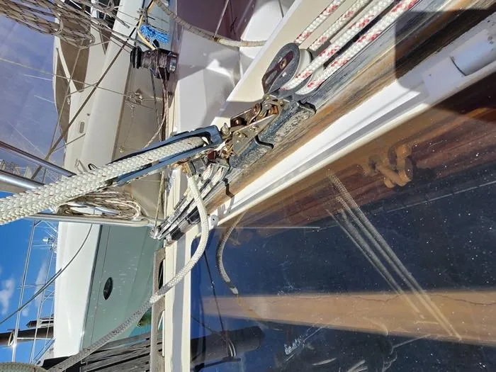 Slide: The Image of 1983 Morgan Schooner sailboat deck with rigging and ropes under clear blue sky. - 23