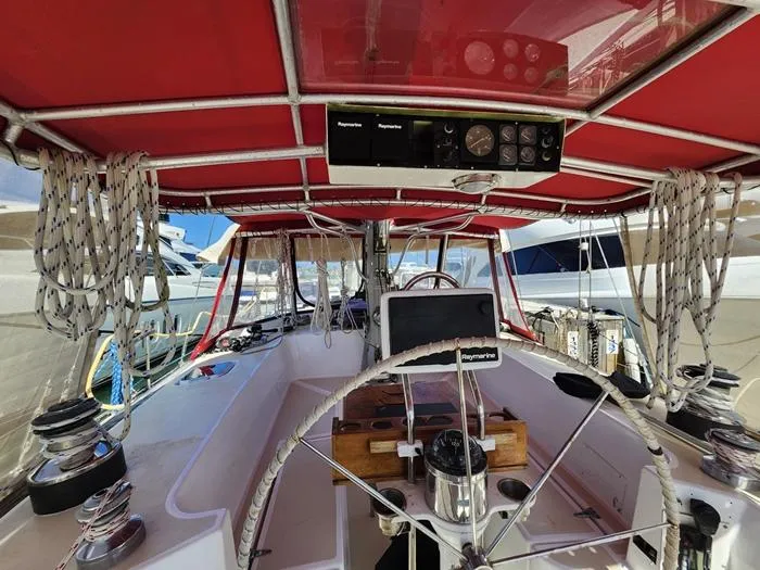 Slide: The Image of 1983 Morgan Schooner cockpit with red canopy, steering wheel, and nautical equipment. - 28