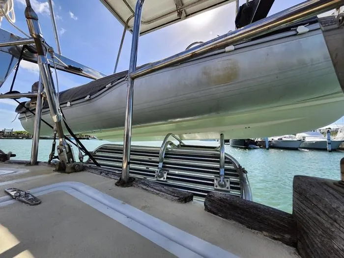 Slide: The Image of 1983 Morgan Schooner with dinghy, docked in a marina under clear blue skies. - 33