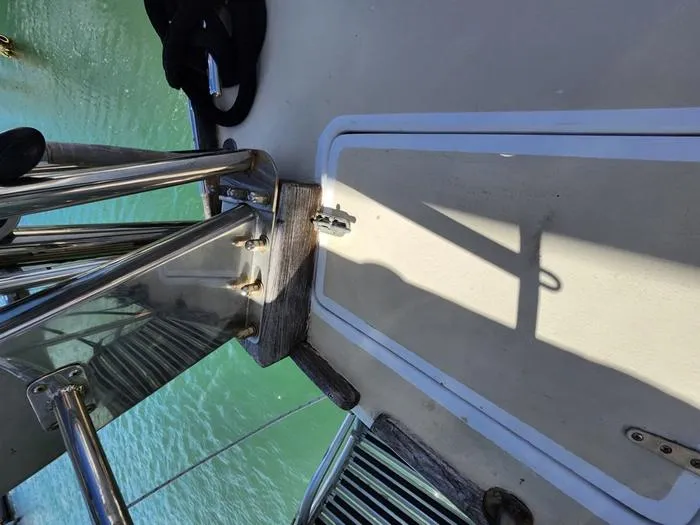 Slide: The Image of 1983 Morgan Schooner deck with stainless steel fittings and wooden trim, overlooking water. - 35