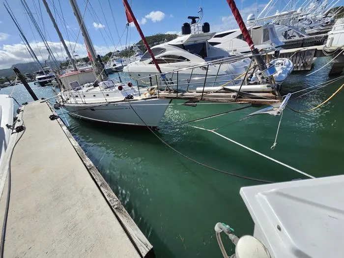 Slide: The Image of 1983 Morgan Schooner docked in a marina with clear blue water and other boats. - 40