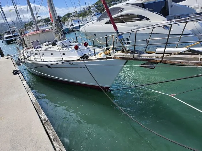 Slide: The Image of 1983 Morgan Schooner docked in a marina, surrounded by clear blue water and other boats. - 41