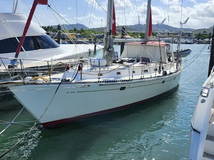 Slide: The Image of 1983 Morgan Schooner sailboat docked in a marina under a clear sky. - 42