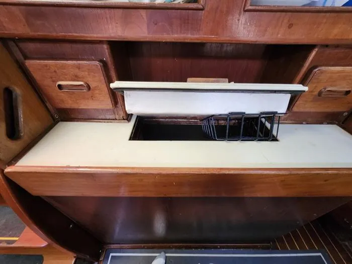 Slide: The Image of 1983 Morgan Schooner interior with wooden cabinetry and storage compartment. - 46