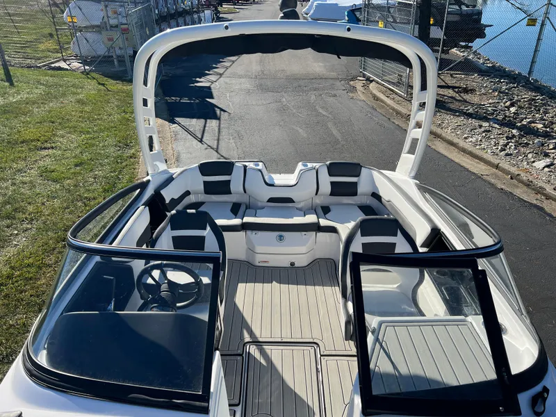 Slide: The Image of 2025 Yamaha Boats 195S interior with open cockpit and seating, docked near water. - 16