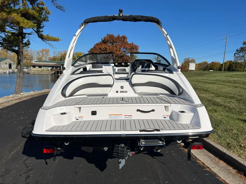 Slide: The Image of 2025 Yamaha Boats 195S, sleek design, rear view, parked near a lake. - 6