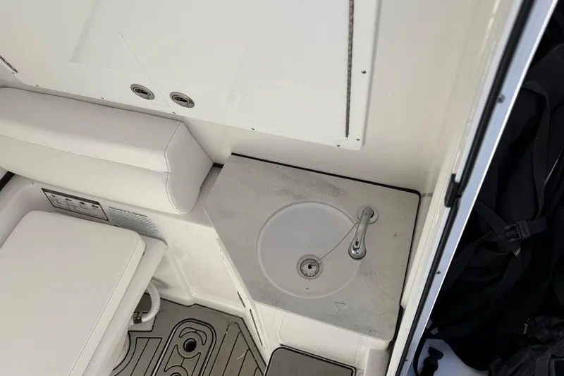 Slide: The Image of 2025 Sportsman Open 302 Center Console interior with sink and seating area. - 16