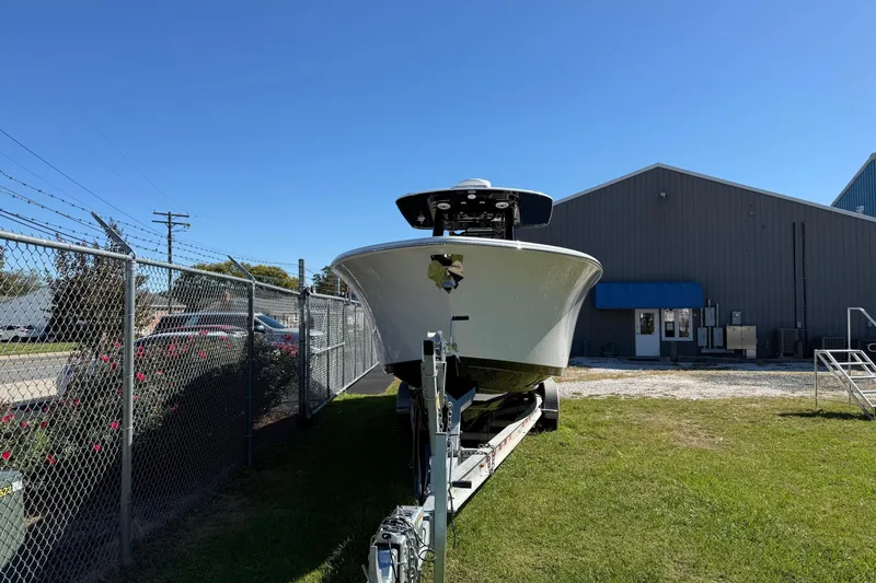 Slide: The Image of 2025 Sportsman Open 302 Center Console boat on trailer near industrial building. - 3