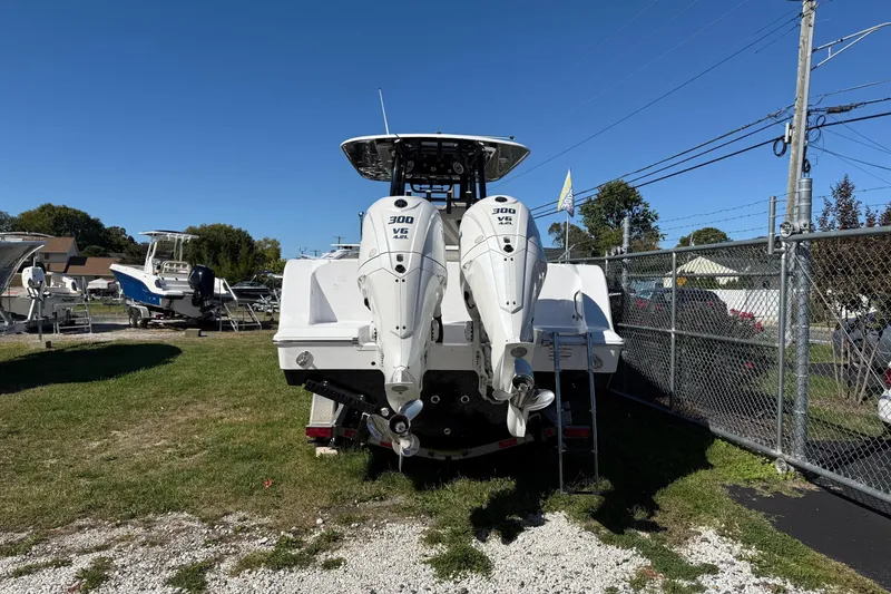 Slide: The Image of 2025 Sportsman Open 302 Center Console boat with twin 300 V6 engines, parked outdoors. - 4