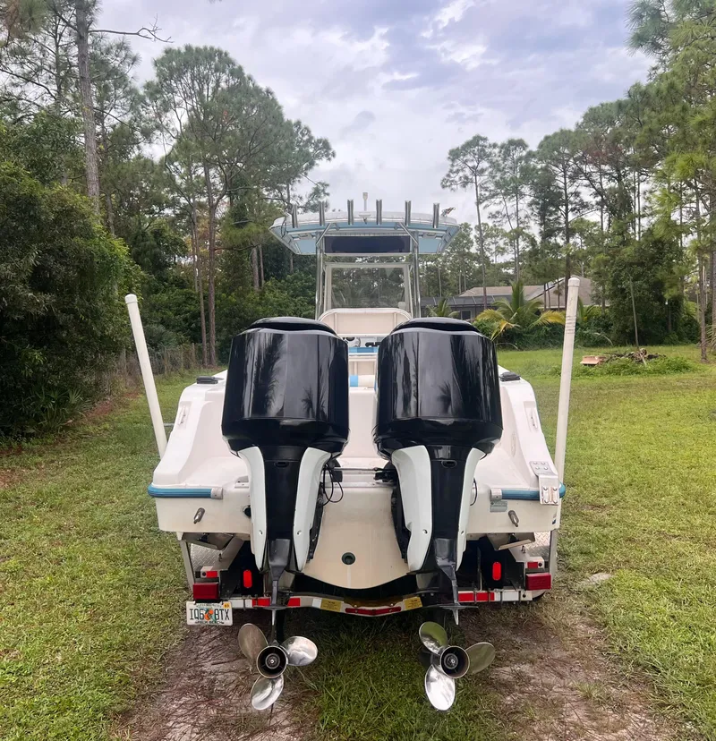 Slide: The Image of 2002 Mako 282 Center Console boat with dual outboard motors, parked on grass. - 2