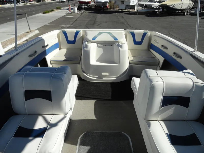 Slide: The Image of 2006 Bayliner 195 Bowrider interior with white and blue seating, parked in a marina. - 13
