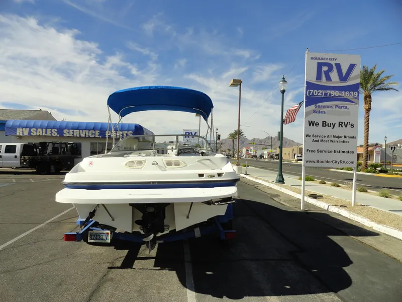 Slide: The Image of 2006 Bayliner 195 Bowrider boat parked at RV sales lot under clear sky. - 18