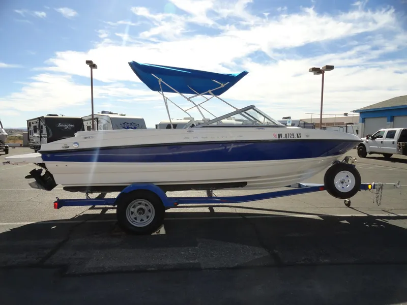 Slide: The Image of 2006 Bayliner 195 Bowrider boat on trailer with blue canopy in parking lot. - 5