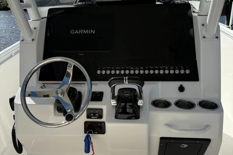 Slide: The Image of Edgewater 280CC 2017 boat dashboard with Garmin display and steering wheel. - 15