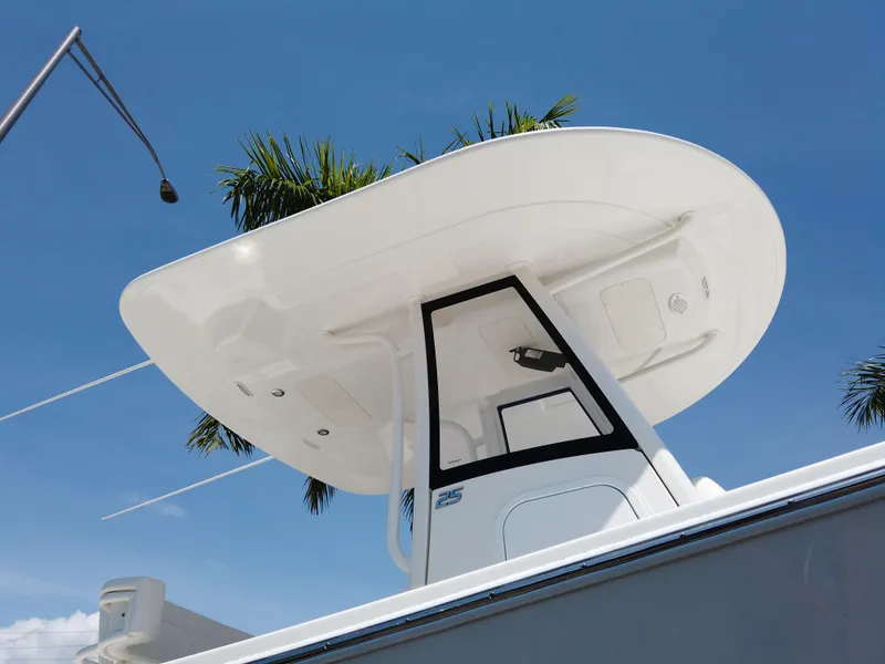 Slide: The Image of 2025 Regulator 25 boat with T-top against a clear blue sky. - 17