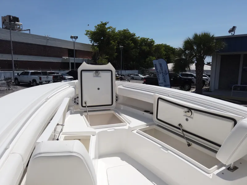 Slide: The Image of 2025 Regulator 25 boat with open storage compartments, docked outdoors. - 20