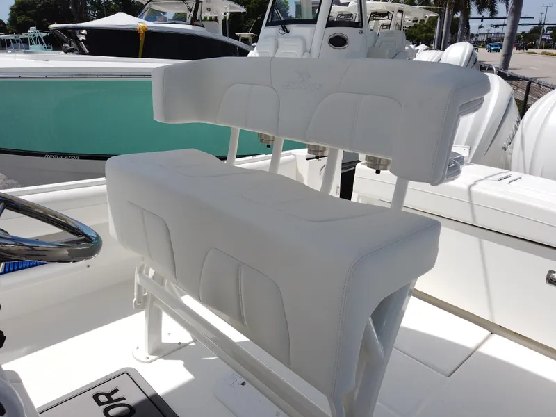 Slide: The Image of 2025 Regulator 25 boat with white cushioned seating and steering wheel. - 6