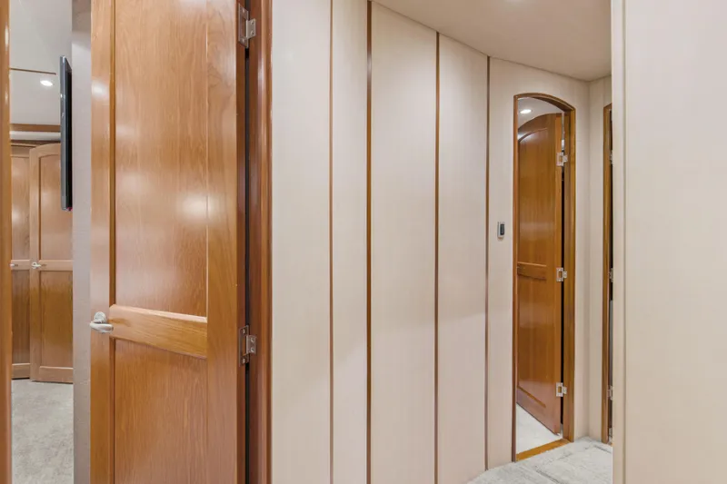 Slide: The Image of Interior hallway of 2015 Viking 70 Convertible yacht with wooden doors and paneling. - 42