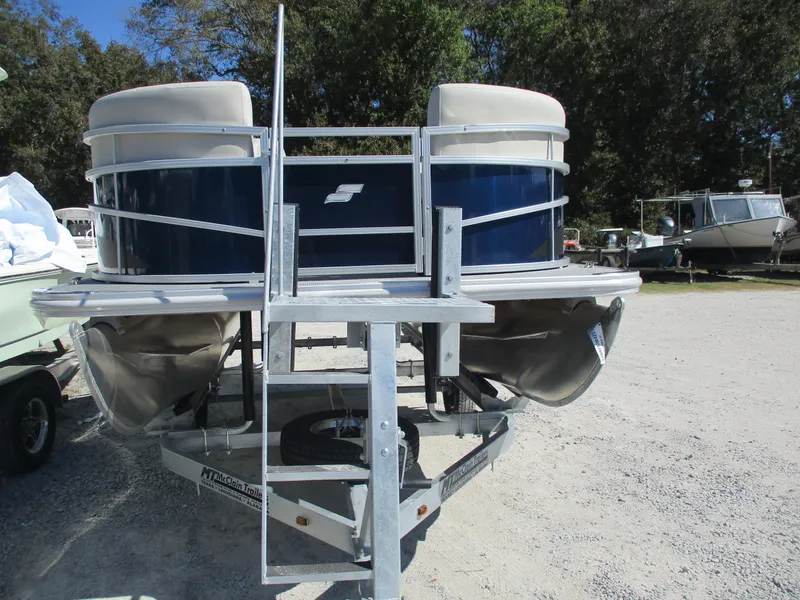 Slide: The Image of 2025 Starcraft LX16R pontoon boat on trailer, parked outdoors. - 3