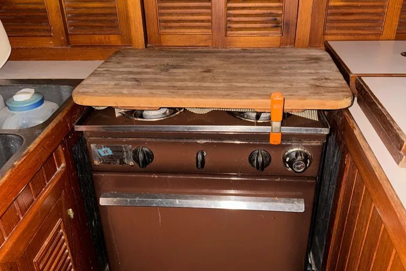 Slide: The Image of 1984 Young Sun 35 yacht interior kitchen with wooden cabinetry and stove. - 12