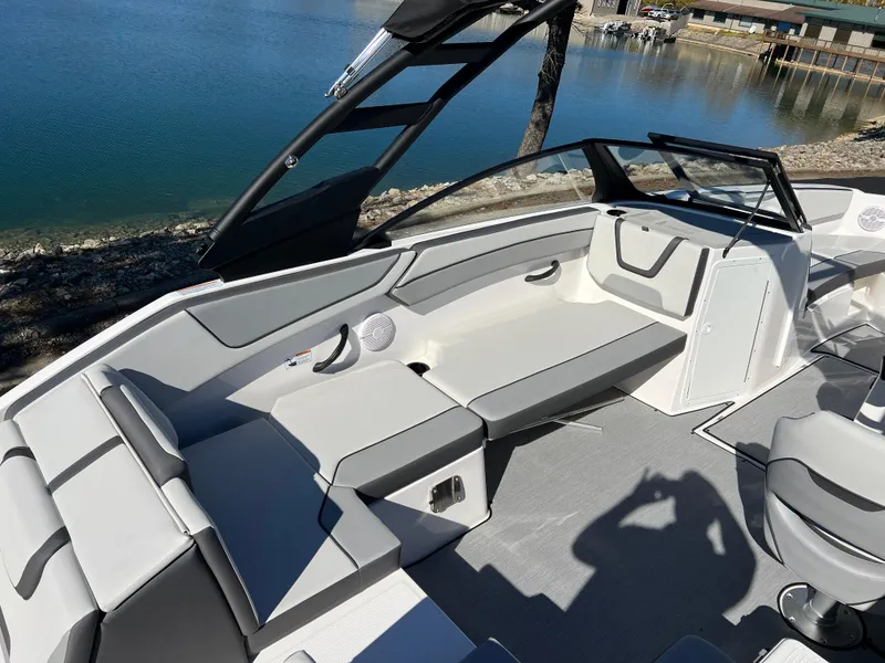 Slide: The Image of 2025 Yamaha Boats AR220 interior with sleek seating by a serene lake. - 11
