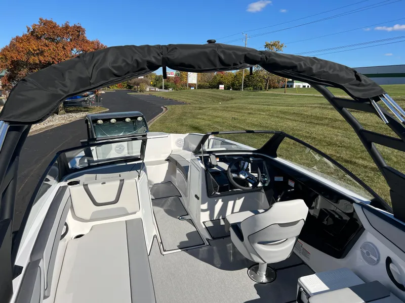 Slide: The Image of 2025 Yamaha Boats AR220 interior with sleek design and modern controls, parked outdoors. - 13