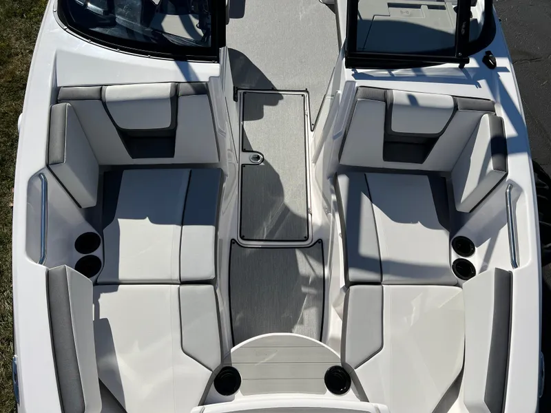 Slide: The Image of 2025 Yamaha Boats AR220 interior seating with cup holders, gray and white upholstery. - 18