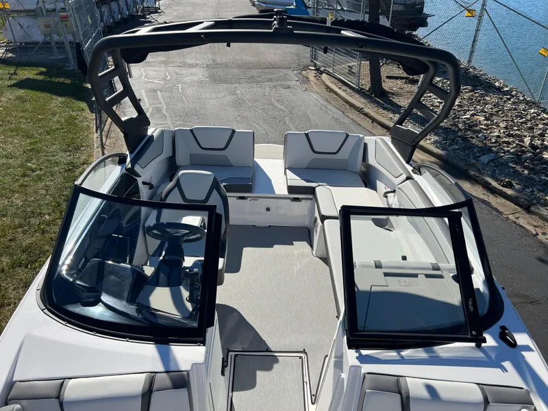 Slide: The Image of 2025 Yamaha Boats AR220, sleek design, spacious seating, docked by the water. - 19