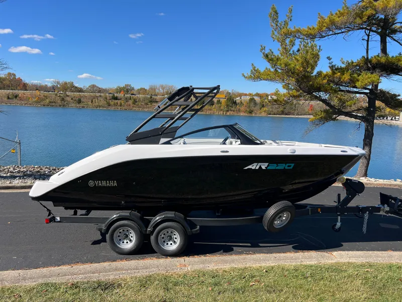 Slide: The Image of 2025 Yamaha AR220 boat on trailer by a scenic lake. - 4