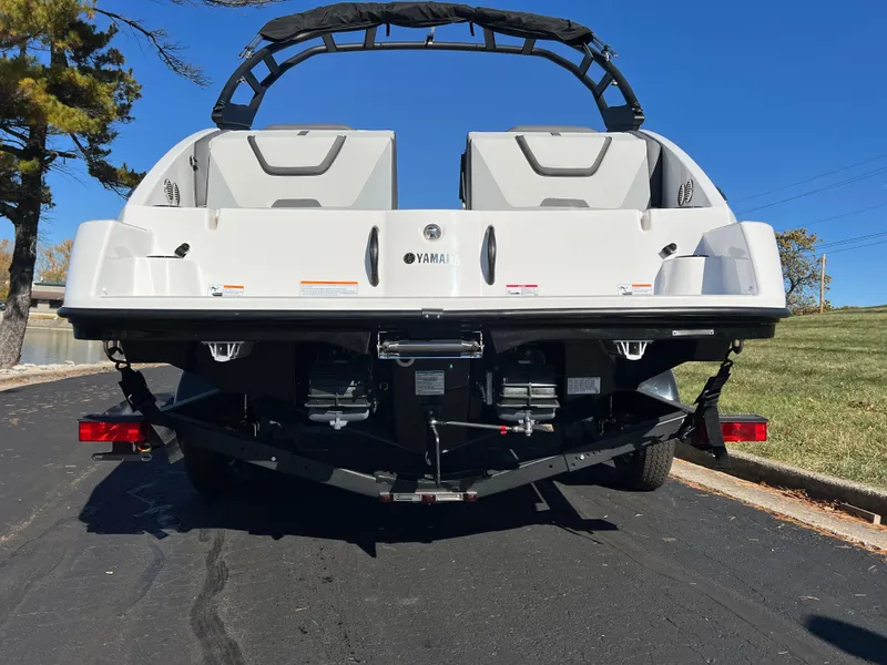 Slide: The Image of 2025 Yamaha Boats AR220 rear view on trailer, parked outdoors. - 7